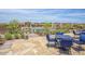 Outdoor pool patio with stone flooring and comfortable blue cushioned chairs, ideal for poolside lounging and entertaining at 16389 W Fawn Dr, Goodyear, AZ 85338