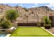 A perfectly manicured putting green blends seamlessly with the surrounding desert landscape, offering a tranquil retreat at 16389 W Fawn Dr, Goodyear, AZ 85338