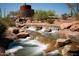Close-up of stone water feature with cascading waterfalls and desert landscaping at Estrella community at 16389 W Fawn Dr, Goodyear, AZ 85338