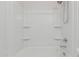 A white tub/shower combination with built-in shelving at 17376 W Via De Luna Dr, Surprise, AZ 85387