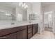 The primary bathroom includes double sinks, tile flooring, and a view into the walk in closet and enclosed shower at 17376 W Via De Luna Dr, Surprise, AZ 85387