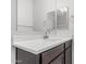 Bathroom vanity with dark wood cabinets, a white countertop, and a large mirror at 17376 W Via De Luna Dr, Surprise, AZ 85387