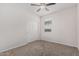 This bedroom features neutral carpet, a ceiling fan, a window, and a closet at 17376 W Via De Luna Dr, Surprise, AZ 85387