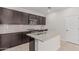 Modern kitchen with an island, dark wood cabinets, granite countertops, subway tile backsplash, and stainless steel appliances at 17376 W Via De Luna Dr, Surprise, AZ 85387