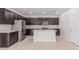Spacious kitchen with dark cabinets, stainless steel appliances, and center island at 17376 W Via De Luna Dr, Surprise, AZ 85387