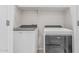A laundry room with a white washer and dryer and wire shelving at 17376 W Via De Luna Dr, Surprise, AZ 85387