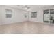 An open-concept living room with tile flooring, ceiling fan, and sliding glass door to the backyard at 17376 W Via De Luna Dr, Surprise, AZ 85387