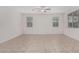 Bright and airy living room with tile flooring, ceiling fan, and two windows at 17376 W Via De Luna Dr, Surprise, AZ 85387