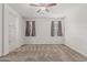 The main bedroom features plush carpet, neutral paint, ceiling fan, and view of the en suite bathroom with shower at 17376 W Via De Luna Dr, Surprise, AZ 85387