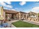 Charming backyard featuring a covered patio, hot tub, and lush artificial grass, perfect for outdoor living at 17419 W Georgia Dr, Surprise, AZ 85388