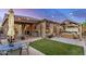 Inviting backyard featuring a patio, lush lawn, string lights, and a covered hot tub at 17419 W Georgia Dr, Surprise, AZ 85388
