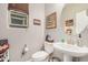 Charming powder room with decorative mirror, pedestal sink and natural light at 17419 W Georgia Dr, Surprise, AZ 85388