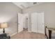 Neutral bedroom features a double door closet, open doorway, and a soft carpet at 17419 W Georgia Dr, Surprise, AZ 85388