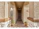 Charming entryway with textured walls, decorative iron door, and potted plants at 17419 W Georgia Dr, Surprise, AZ 85388