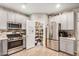 Open kitchen with stainless steel appliances, a pantry, and wood-look tile flooring provides ample storage at 17419 W Georgia Dr, Surprise, AZ 85388