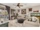 Bright living room with a sliding glass door, ceiling fan, and an ornate sunburst wall decoration for added charm at 17419 W Georgia Dr, Surprise, AZ 85388