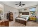 The main bedroom features a large bed, ceiling fan, two windows, and carpeted floors at 17419 W Georgia Dr, Surprise, AZ 85388
