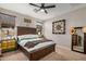 The main bedroom features a large bed, ceiling fan, two windows, and neutral colored walls at 17419 W Georgia Dr, Surprise, AZ 85388