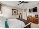This main bedroom features a ceiling fan, wooden accents, and a mounted TV at 17419 W Georgia Dr, Surprise, AZ 85388