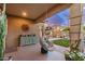 Inviting covered patio features a hanging chair, outdoor decor, and a view of the landscaped yard at 17419 W Georgia Dr, Surprise, AZ 85388