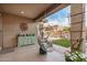 Charming covered patio with hanging chair, adjacent to a landscaped backyard with comfortable seating at 17419 W Georgia Dr, Surprise, AZ 85388