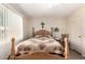 Bedroom features wood bed frame, light walls, and a decorative cross on the wall at 17804 N Del Webb Blvd, Sun City, AZ 85373