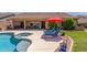 Backyard pool area with desert landscaping, lounge chairs under a red umbrella, and a covered patio at 17836 N 52Nd Pl, Scottsdale, AZ 85254