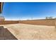 Spacious backyard features dirt landscaping and a block wall for privacy at 18210 W Hess St, Goodyear, AZ 85338