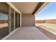 The covered patio includes sliding glass doors with a plain wall and concrete flooring at 18210 W Hess St, Goodyear, AZ 85338