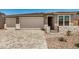 Charming single Gathering home featuring stone accents, brick driveway and well manicured desert landscaping at 18210 W Hess St, Goodyear, AZ 85338
