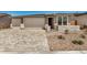 Three-car garage with decorative stone and a paved driveway leading to the entrance gate at 18210 W Hess St, Goodyear, AZ 85338