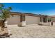 Three-car garage with stone accents and a paved driveway leading to the entrance at 18210 W Hess St, Goodyear, AZ 85338