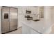 The modern kitchen featuring stainless steel appliances, white cabinetry, an island and stone countertops at 18210 W Hess St, Goodyear, AZ 85338