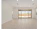 Bright living room features light tile floors, white walls, recessed lighting, and glass patio doors at 18210 W Hess St, Goodyear, AZ 85338