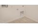 Laundry utility room area with tile floors, plain colored wall, and utility hookups at 18210 W Hess St, Goodyear, AZ 85338