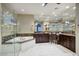 Elegant bathroom with a glass shower, a soaking tub, and dual dark wood vanity sinks at 18515 N 97Th Way, Scottsdale, AZ 85255