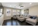 Living room with a large sectional couch, ceiling fan, and many windows at 18515 N 97Th Way, Scottsdale, AZ 85255