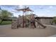 Community playground featuring slides, climbing structures, and sandy play areas with desert landscape views at 18515 N 97Th Way, Scottsdale, AZ 85255
