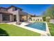 Inviting backyard features a pristine pool, manicured lawn, and covered patio, creating an ideal outdoor retreat at 18515 N 97Th Way, Scottsdale, AZ 85255