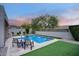 A backyard swimming pool features a patio, green grass and lush landscaping at 18515 N 97Th Way, Scottsdale, AZ 85255