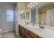 Bathroom with double sinks, spacious mirror, and neutral tile flooring at 18581 E Aubrey Glen Rd, Queen Creek, AZ 85142