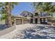 Stately two-story home showcases a three-car garage and wide driveway with desert landscaping at 18581 E Aubrey Glen Rd, Queen Creek, AZ 85142