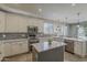 Bright kitchen with white cabinetry, mosaic backsplash, and a central island at 18581 E Aubrey Glen Rd, Queen Creek, AZ 85142