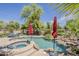 Inviting pool and hot tub with rock waterfall feature and patio umbrellas at 18581 E Aubrey Glen Rd, Queen Creek, AZ 85142