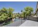 View of the backyard pool with waterfalls and mature landscaping from the upstairs deck at 18581 E Aubrey Glen Rd, Queen Creek, AZ 85142