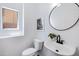 Bright powder room features a pedestal sink, round mirror, modern faucet and adjacent window at 19172 E Kingbird Dr, Queen Creek, AZ 85142