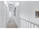 Light-filled hallway with neutral carpet and white walls provides access to various rooms in the home at 19172 E Kingbird Dr, Queen Creek, AZ 85142