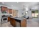 Modern kitchen boasts granite countertops, stainless steel appliances, and island with bar seating, seamlessly flowing into living spaces at 19172 E Kingbird Dr, Queen Creek, AZ 85142