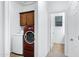 Modern laundry room features a red washer and dryer, along with upper cabinets for storage at 19172 E Kingbird Dr, Queen Creek, AZ 85142