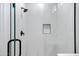 Modern shower features sleek black trim, beautiful white marbled tiling, a recessed niche, and a contemporary showerhead at 19172 E Kingbird Dr, Queen Creek, AZ 85142